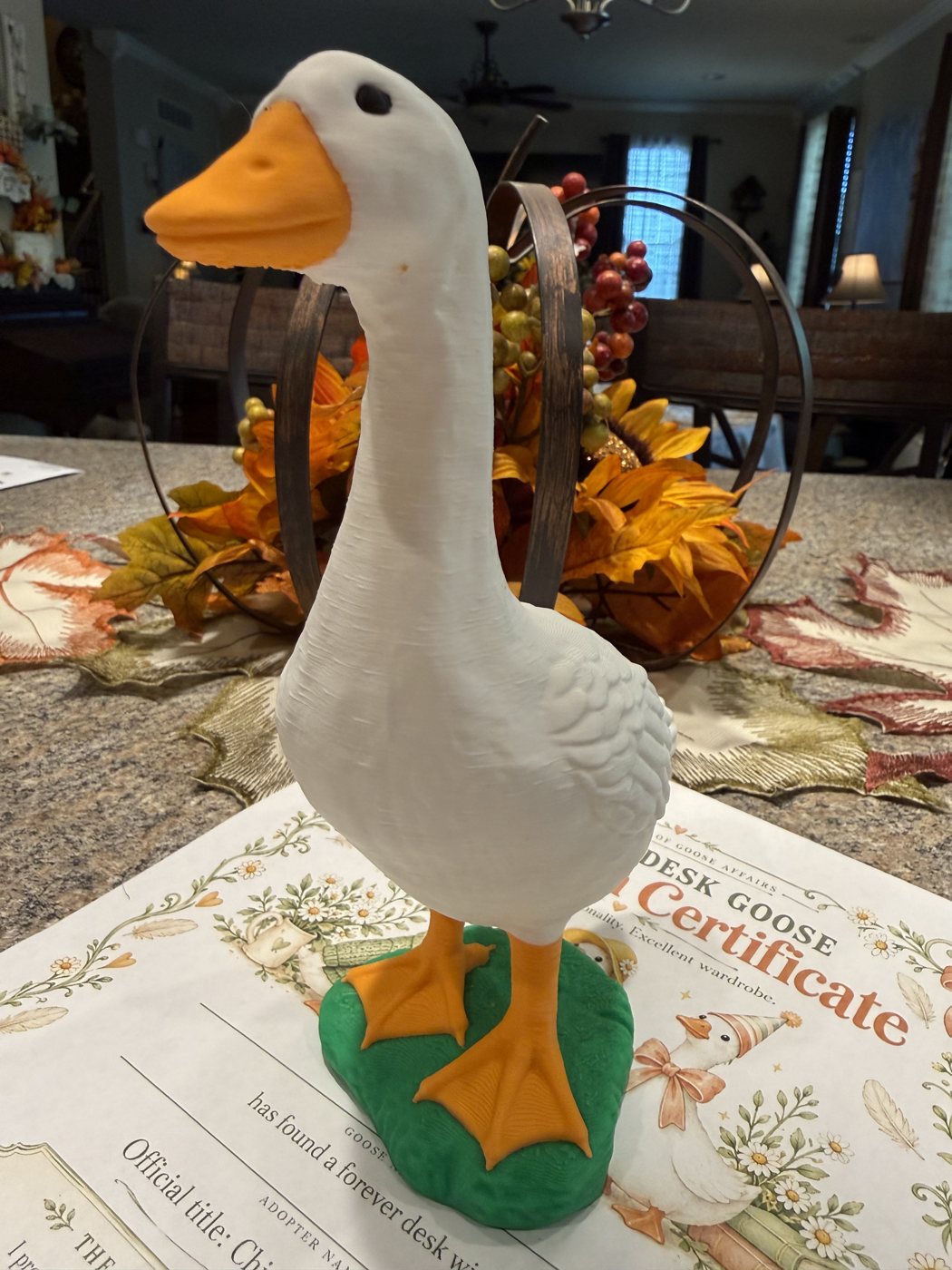 White 3D printed desk goose with an orange beak on a green base